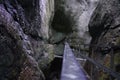 a rail is going through a gorge as a person walks Royalty Free Stock Photo