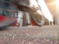 Rail platform with red commuter train in motion blur, man with mike blurred in foreground Royalty Free Stock Photo