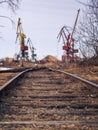 Rail road tracks under the gantry cranes on the berth of sea merchant port Royalty Free Stock Photo