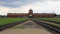 Rail tracks, gate house with guard tower in the background, of Auschwitz concentration camp