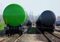 green freight train in rail yard perspective with tanker cars