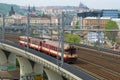 The railcar with wagons passes local train on a railway viaduct. Prague