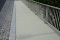 Railing at the bridge with vertical fence bars anchored to the ground with four concrete screws. plastic caps Royalty Free Stock Photo