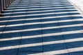 Railing shadows reflected on floor of a pedestrian bridge Royalty Free Stock Photo
