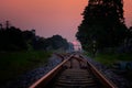 Railroad against beautiful sky at sunset. Industrial landscape with railway station, colorful gold sky, trees and grass, yellow Royalty Free Stock Photo