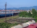 Railroad in the city against the backdrop of mountains. Many railway paths. Wagons and trains on the tracks. unloading station. Royalty Free Stock Photo