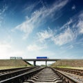Railroad closeup and bridge with autos under blue sky Royalty Free Stock Photo