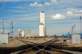 Railroad Crossing with Distant Grain Elevator Silo Royalty Free Stock Photo
