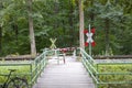 Railroad  crossing in a forest for pedestrians with andreas cross and bars for protection Royalty Free Stock Photo