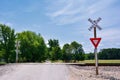 Railroad crossing sign against blue sky background. Royalty Free Stock Photo