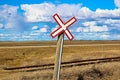 Railroad crossing sign along gravel road Royalty Free Stock Photo