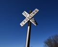 A railroad crossing sign with a clear blue sky. Royalty Free Stock Photo