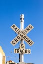 Railroad crossing sign under blue sky Royalty Free Stock Photo
