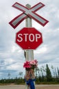 Railroad crossing stop sign with flowers Royalty Free Stock Photo