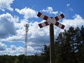 Railroad Crossing Warning Street Sign with Forest and Broadcasting Tower at Background Royalty Free Stock Photo