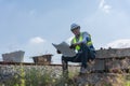 Railroad Engineer Sits on Concrete Block with Blueprints, Civil Engineer Planning Project at a Railway Construction Site, Royalty Free Stock Photo