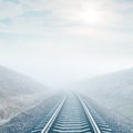 Railroad in fog and sun in clouds Royalty Free Stock Photo