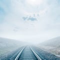 Railroad in fog. sun in misty clouds Royalty Free Stock Photo