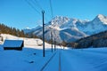 Railroad line and barns in alpine landscape by blue sky