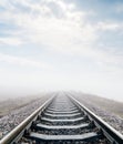 Railroad in meadow with fog and clouds Royalty Free Stock Photo