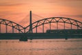 railroad metal bridge silhouette over river of Daugava in Riga,