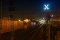 Railroad night scene with blue traffic light and railway station tracks, at dusk, golden tones and colors. Industrial