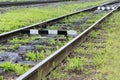 Railroad with old sleepers overgrown with green grass. Industrial concept background. Railroad travel, railway tourism.