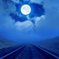 Railroad to horizon in fog and full moon over it Royalty Free Stock Photo