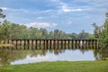 A railroad track bridge over a public lake called Cherokee Lake, in Thomasville Georgia on a Sunny day with a tranquil