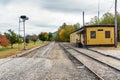 Railroad tracks and a deserted old wooden train station on a cloudy autumn day