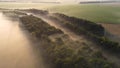 Railroad tracks and forest in the fog at sunrise. Aerial view of the morning landscape. Royalty Free Stock Photo