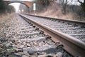 2 Railroad tracks lead towards a bridge