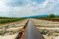 Railroad tracks leading to endless infinity. Meadow landscape and distant mountains. Royalty Free Stock Photo