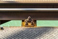 Railroad tracks located on the railroad bridge over the river, close-up on the fastening screw, lying on wooden sleepers, a turquo Royalty Free Stock Photo