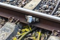 Railroad tracks lying on concrete sleepers, filling large pieces of rock, close-up on the axle counter detection unit.