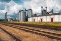 A railroad tracks passing near big steel silos Royalty Free Stock Photo