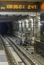 Rails with sleepers in the underground tunnel of the subway, and an elektonnye clock with a scoreboard