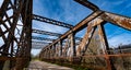 Shot of old rusty bridge set against a countryside and blue sky background