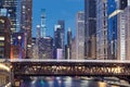 Railway bridge over Chicago River amidst illuminated city