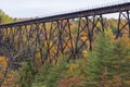 Railway bridge over a river with fall colors in background near Sainte Ursule Waterfall. Canada.