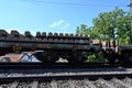 A railway carriage loaded with concrete sleepers stands on the rails.