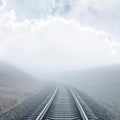 railway goes to horizon in fog under cloudy sky Royalty Free Stock Photo