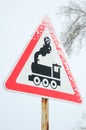 Railway crossing without barrier. A road sign depicting an old black locomotive, located in a red triangle Royalty Free Stock Photo