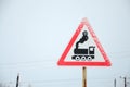 Railway crossing without barrier. A road sign depicting an old black locomotive, located in a red triangle Royalty Free Stock Photo