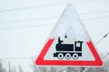 Railway crossing without barrier. A road sign depicting an old black locomotive, located in a red triangle Royalty Free Stock Photo