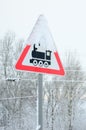 Railway crossing without barrier. A road sign depicting an old black locomotive, located in a red triangle Royalty Free Stock Photo