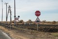 A railway crossing without a barrier. Road sign Stop and artificial hump.