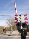 Railway crossing in holland with people on bicycle passing by