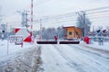 Railway crossing in winter, with raised barriers anti-RAM devices Royalty Free Stock Photo