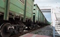 Railway freight cars pass by. Movement of a freight train past the station platform. Wagons carrying cargo. Traffic in the frame a Royalty Free Stock Photo